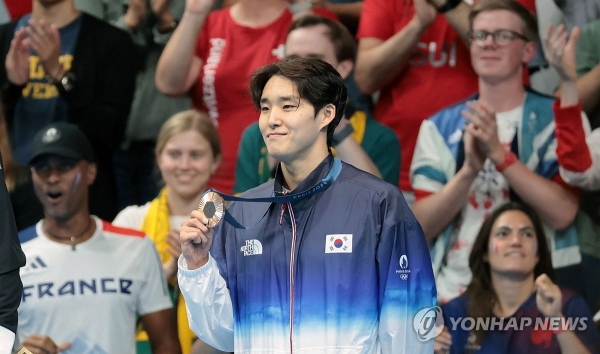 27일(현지시간) 프랑스 파리 라데팡스 아레나에서 열린 2024 파리올림픽 수영 남자 자유형 400m 결승에서 동메달을 차지한 김우민이 시상대에 올라 메달을 들어 보이고 있다. [사진=연합뉴스]