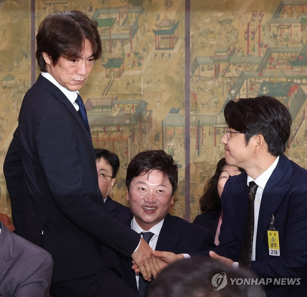 축구 국가대표팀 홍명보 감독이 24일 국회에서 열린 문화체육관광위원회 전체회의에 출석, 박주호 전 대한축구협회 전력강화위원과 악수를 하고 있다. [사진=연합뉴스]